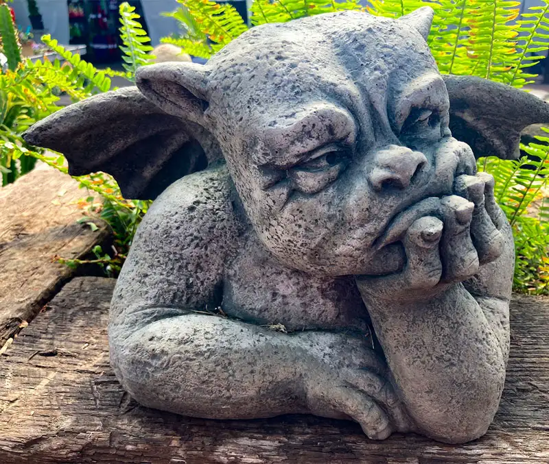 A grumpy gargoyle resting its head in its hand is one of the fun statues you can find at The Dutch Plant Farm store.