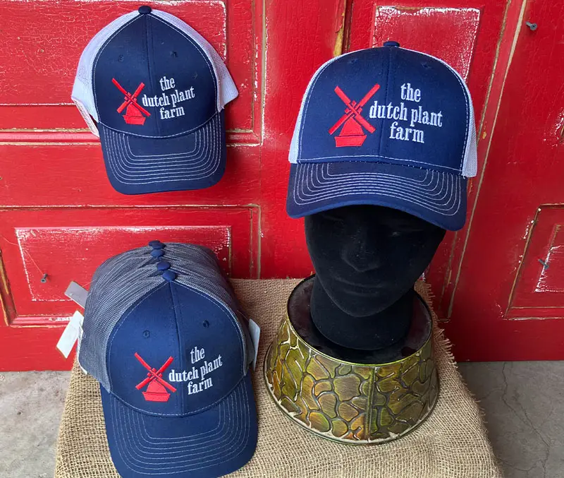 Display of ballcaps embroidered with The Dutch Plant Farm and their logo are some of the accessories available at The Dutch Plant Farm store.